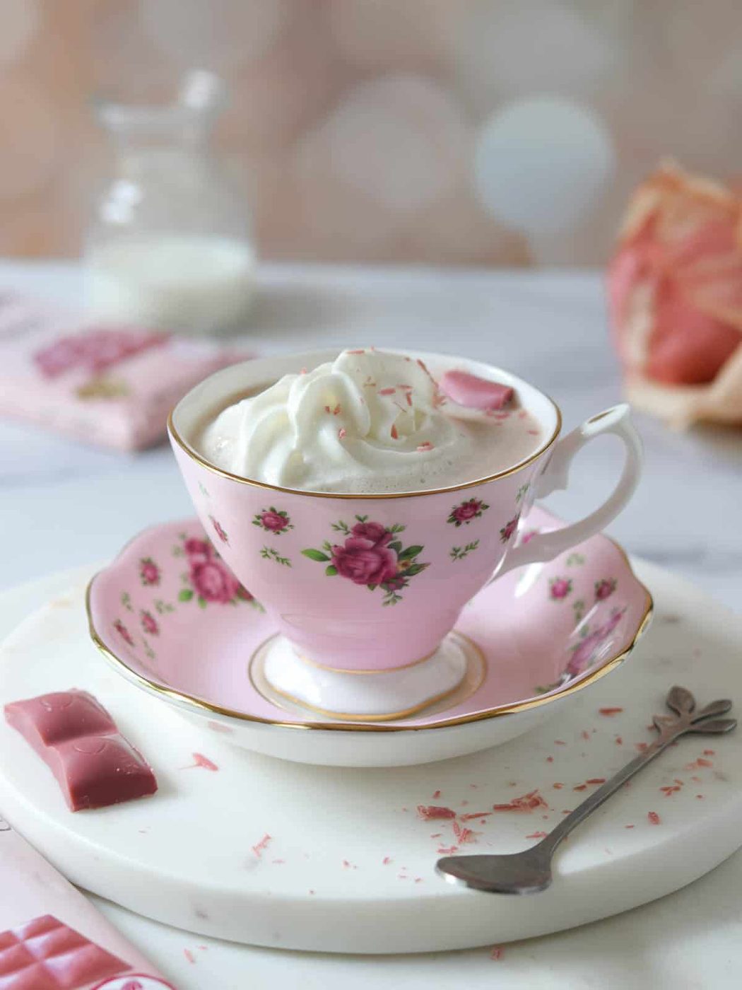 Ruby hot chocolate in a pink mug with whipped cream on top.