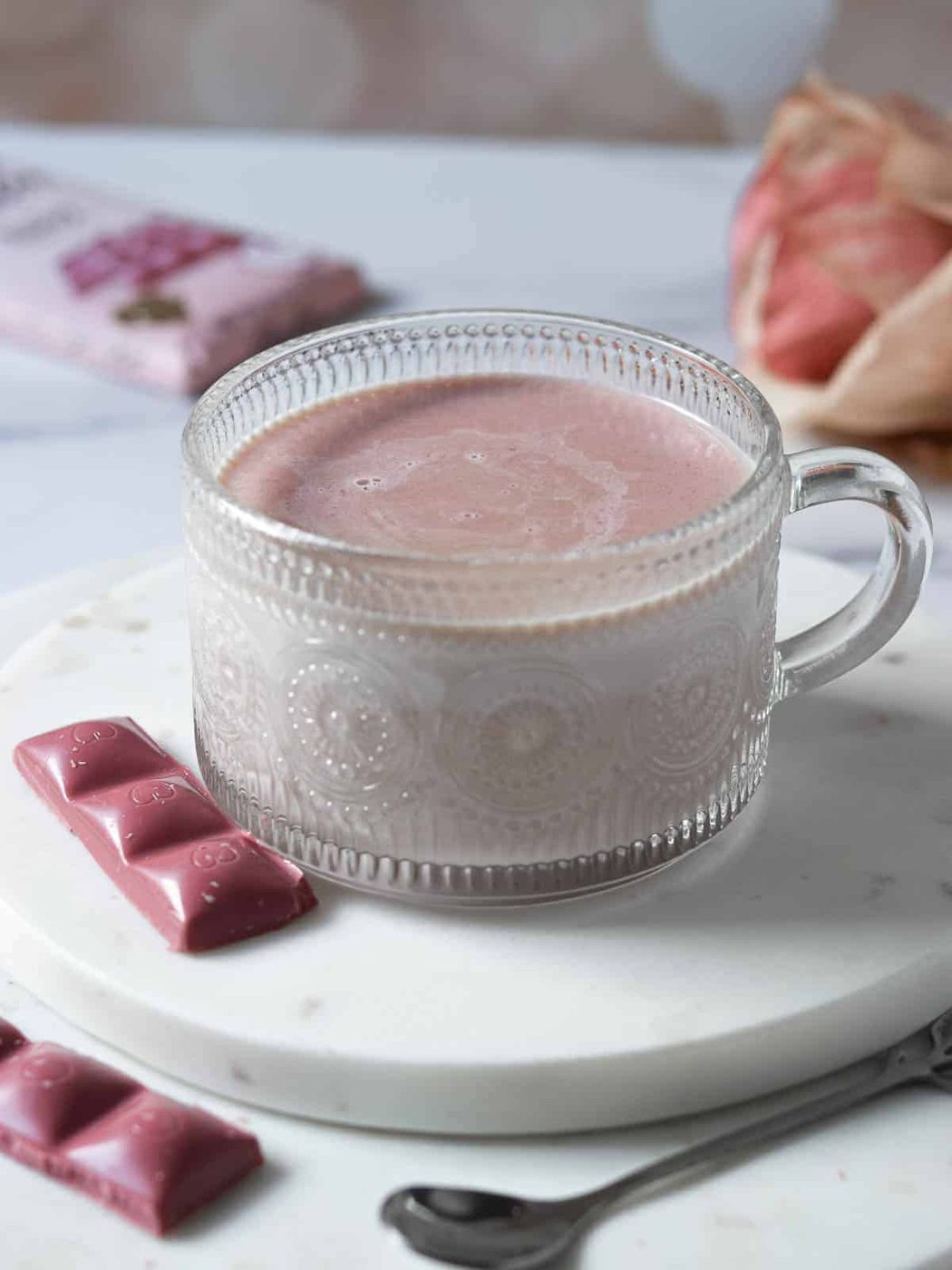 Ruby hot chocolate poured into a clear etched mug.