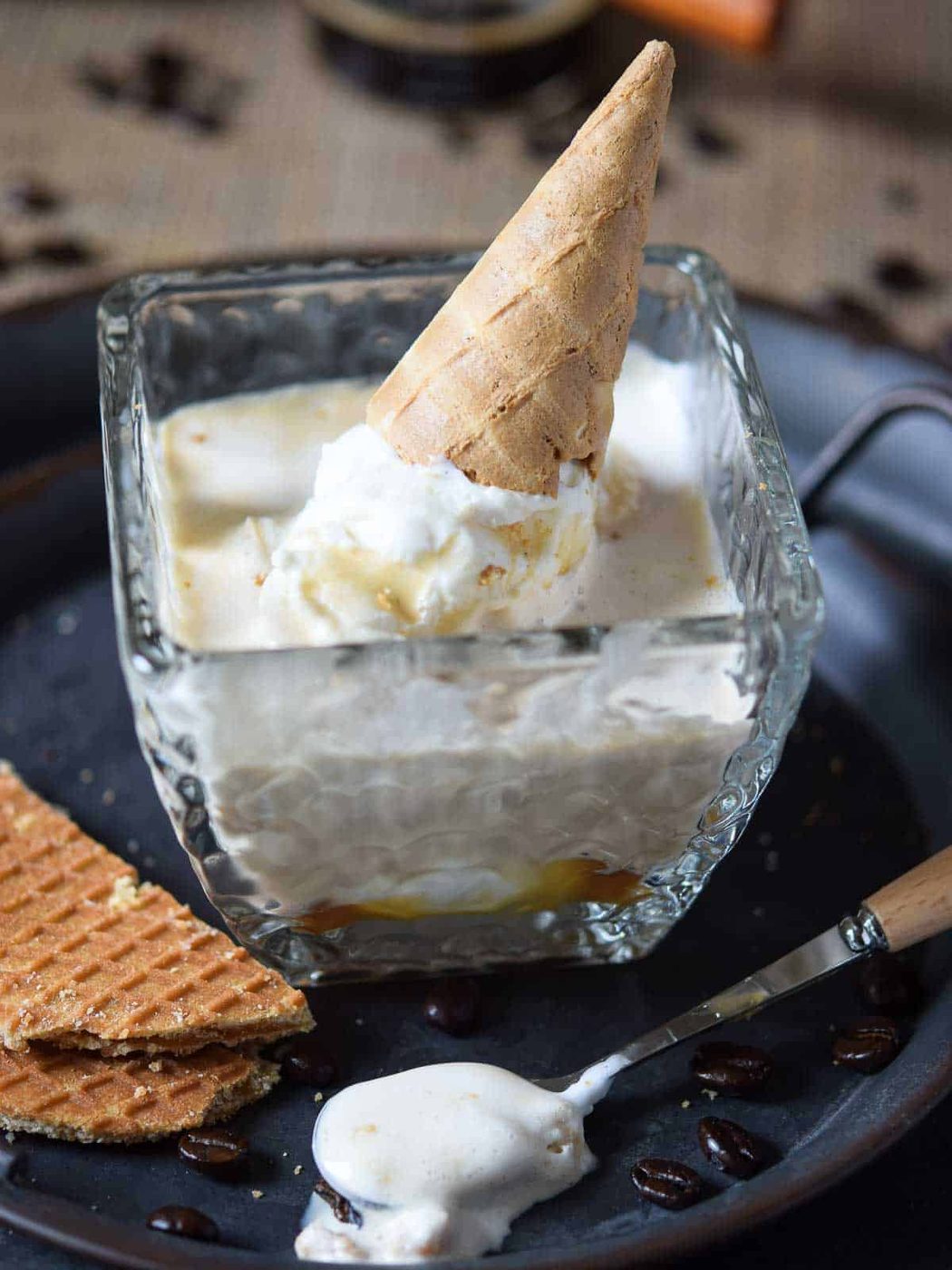 Close-up on an affogato in a clear glass with an ice cream cone on it.