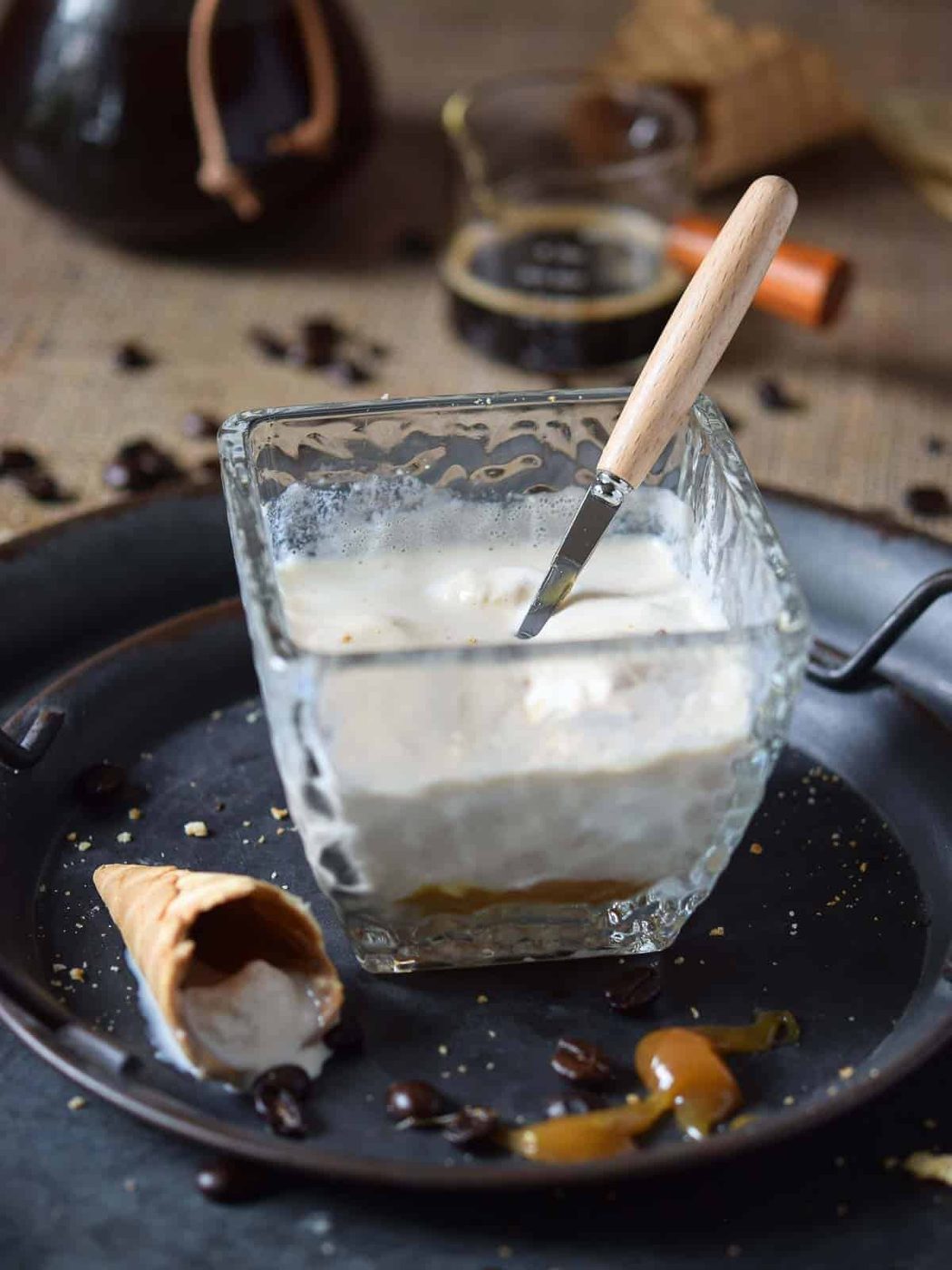 Almost melted affogato in a clear glass on a brown surface.