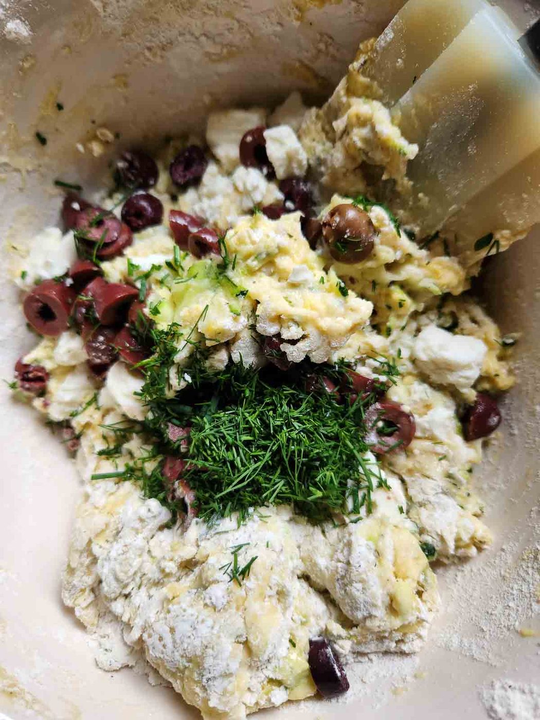 Batter for zucchini bread in a bowl with a spatula.