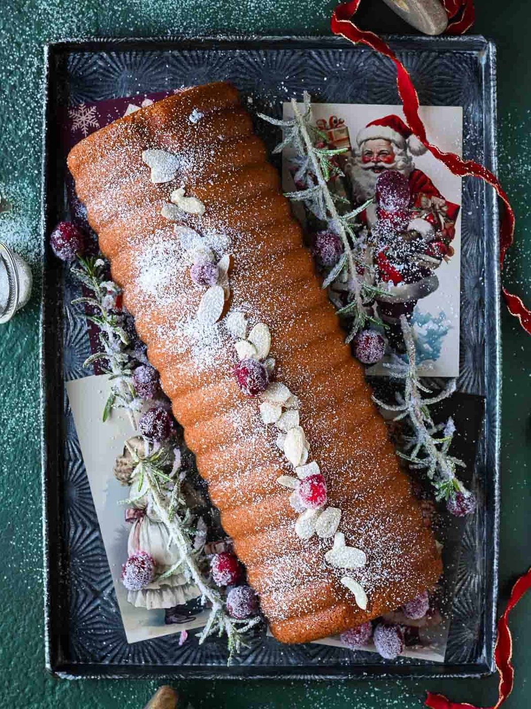 Overhead of an almond cake on a silver tray.