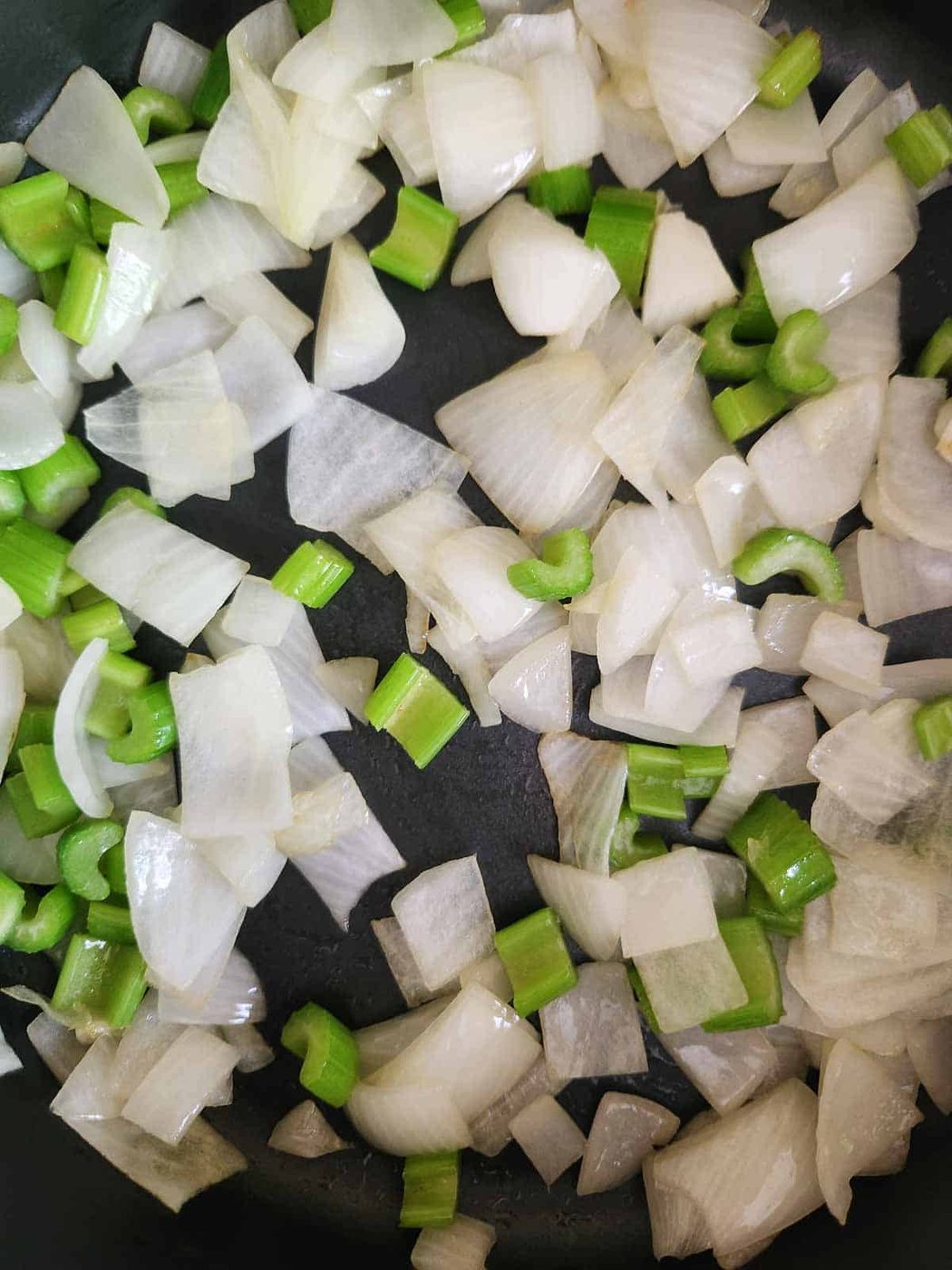 Sautéed celery and onions in a skillet.