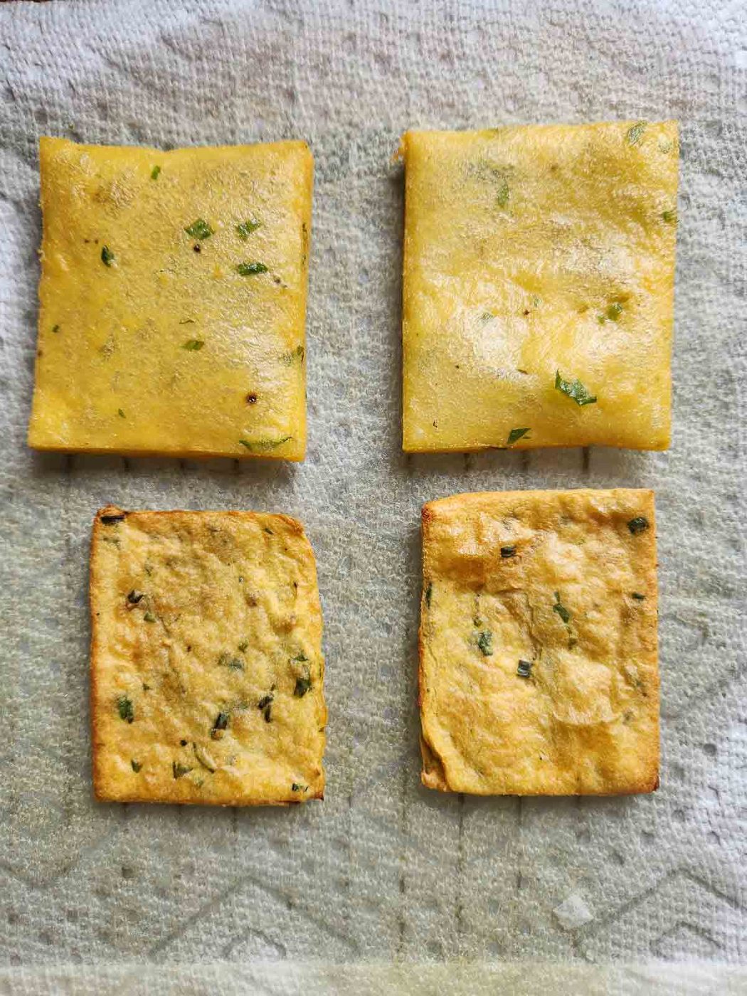 Fried panelle shown next to air-fried panelle on a paper towel.