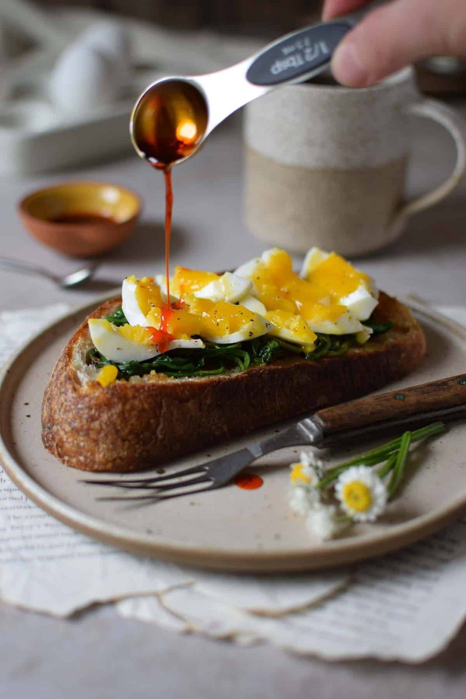 Chili oil drizzled over smashed eggs on toast.