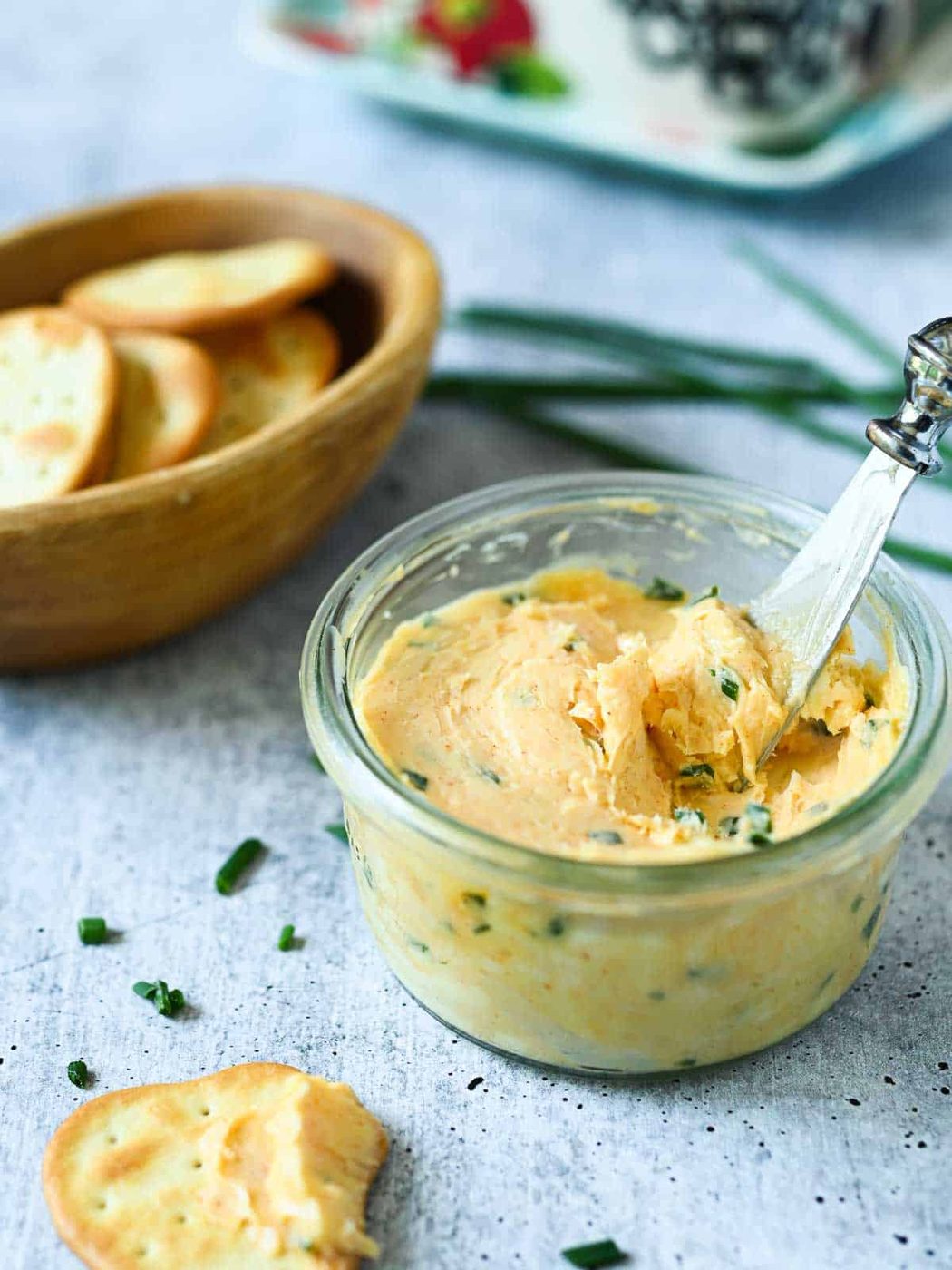 Smoked chive butter in a clear bowl with crackers on the side.