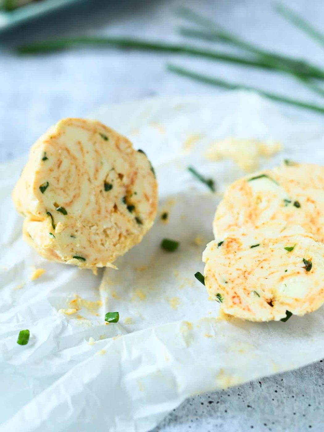 A log of chive butter cut in half.