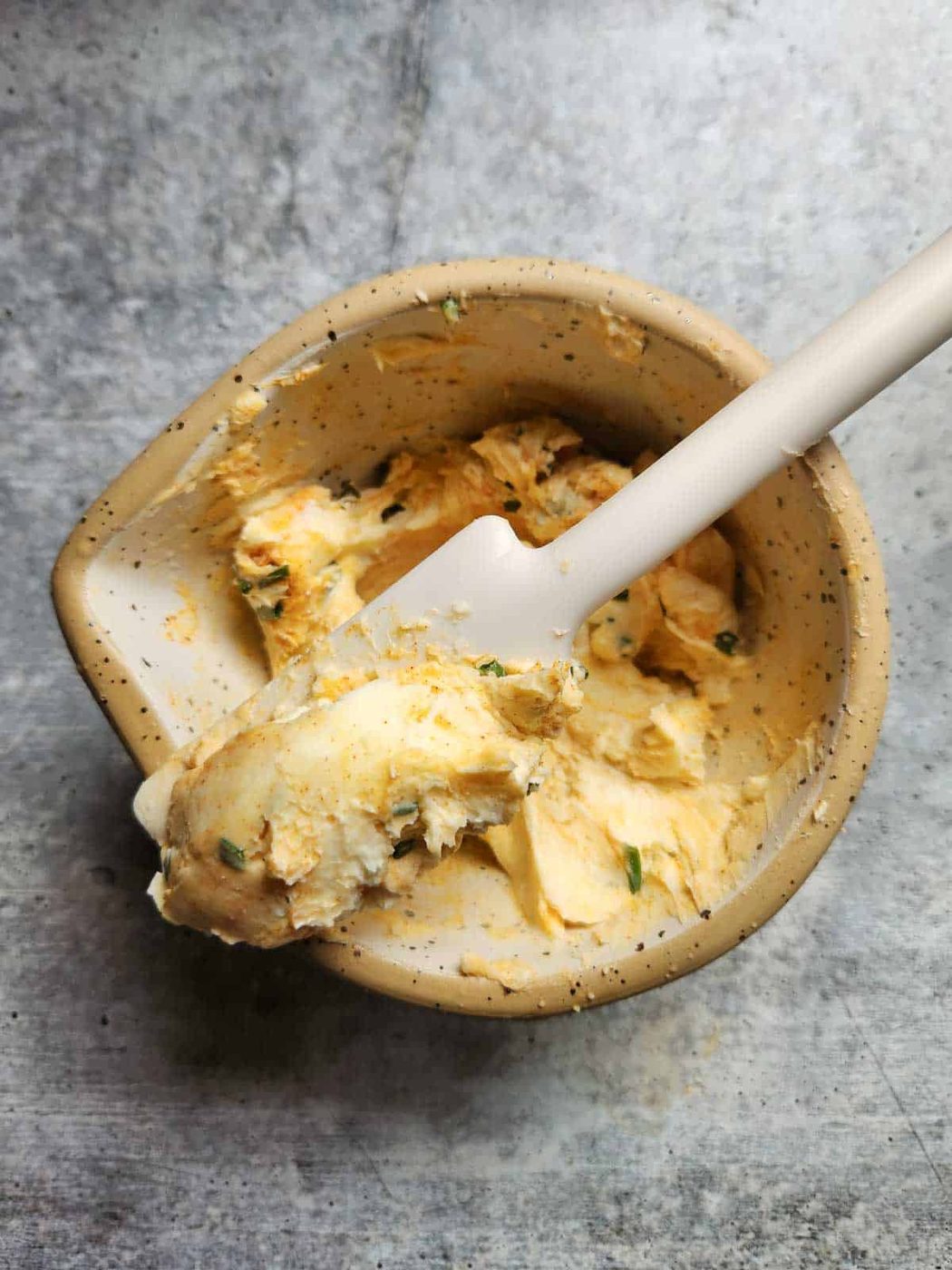 Mixed smoked paprika and chive butter in a small bowl.