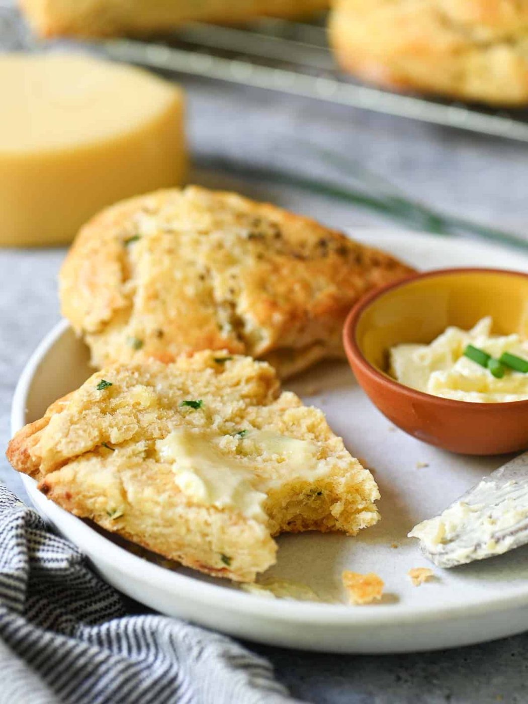 Split scone with melted butter on a white plate.