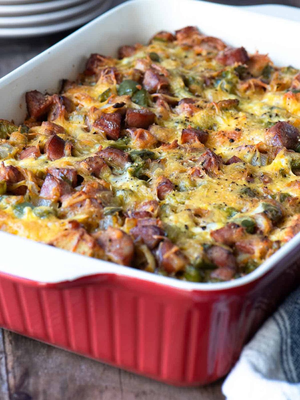 Angled view of a sausage strata in a red baking dish.
