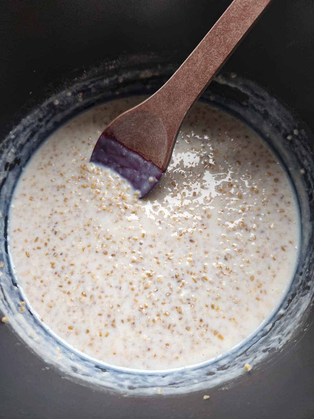 Overhead of oatmeal being stirred in pot.