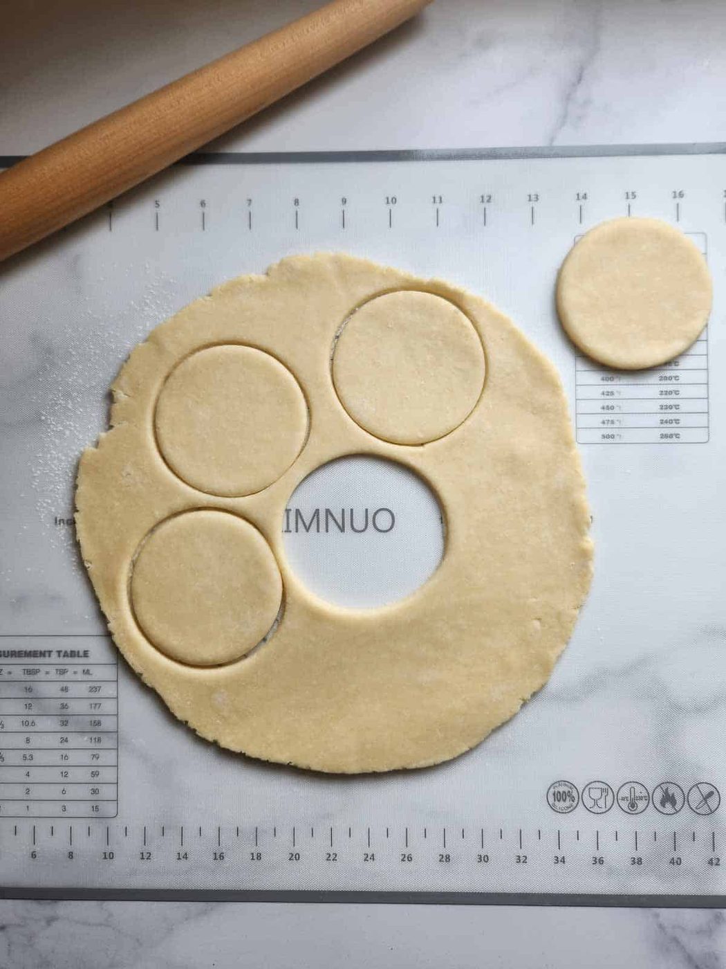 Pie dough being cut in circles for strawberry mini pies.