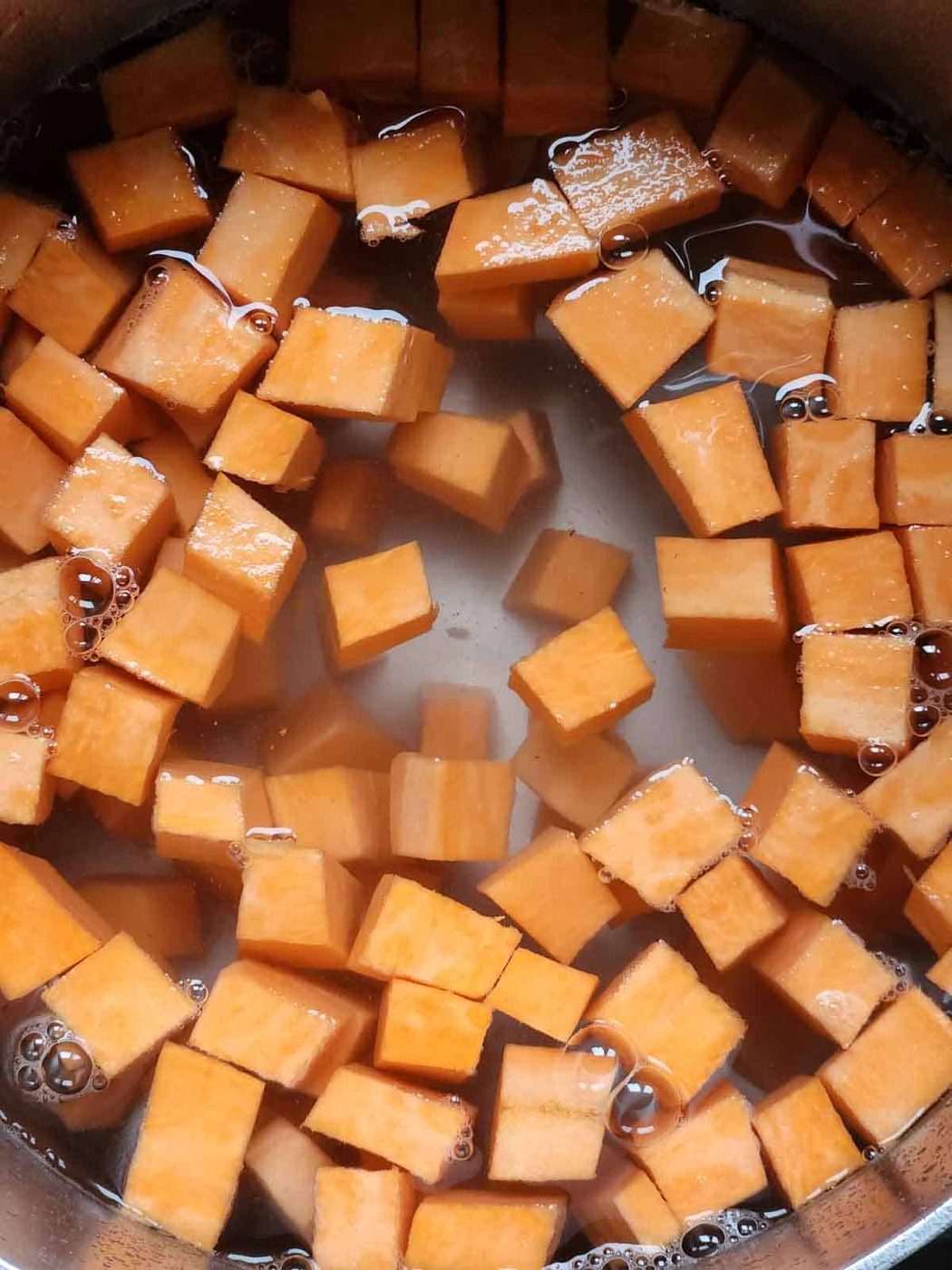 Diced sweet potatoes in a pot of water.