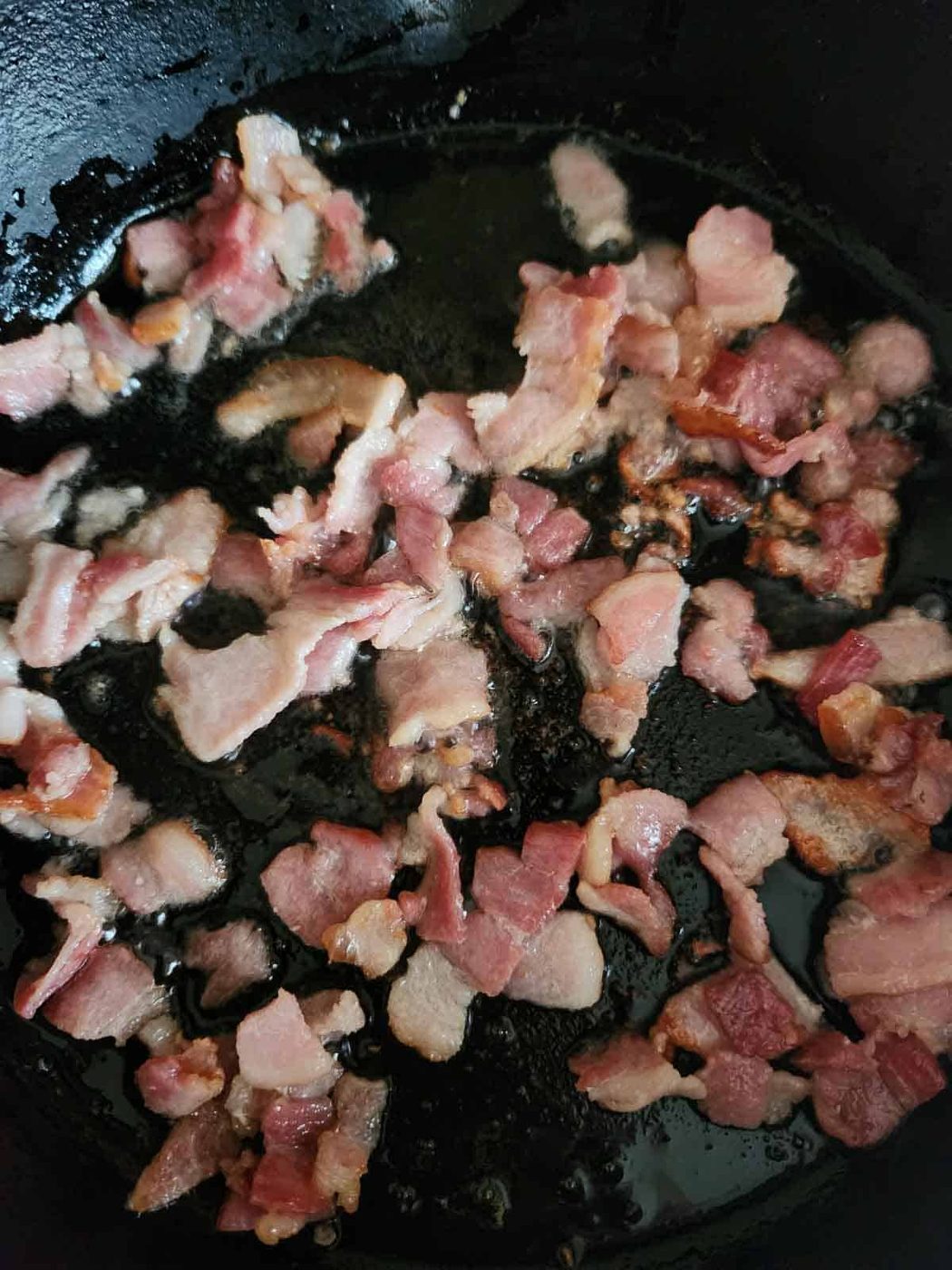 Bacon frying in a skillet.