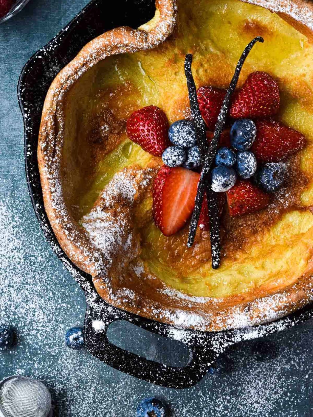 Overhead picture of a vanilla Dutch baby with fruit in the middle.