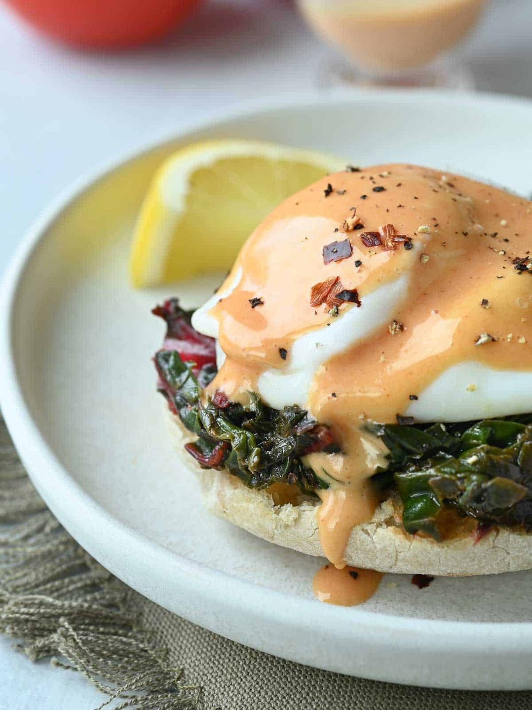 Close-up of eggs Florentine with tomato hollandaise.