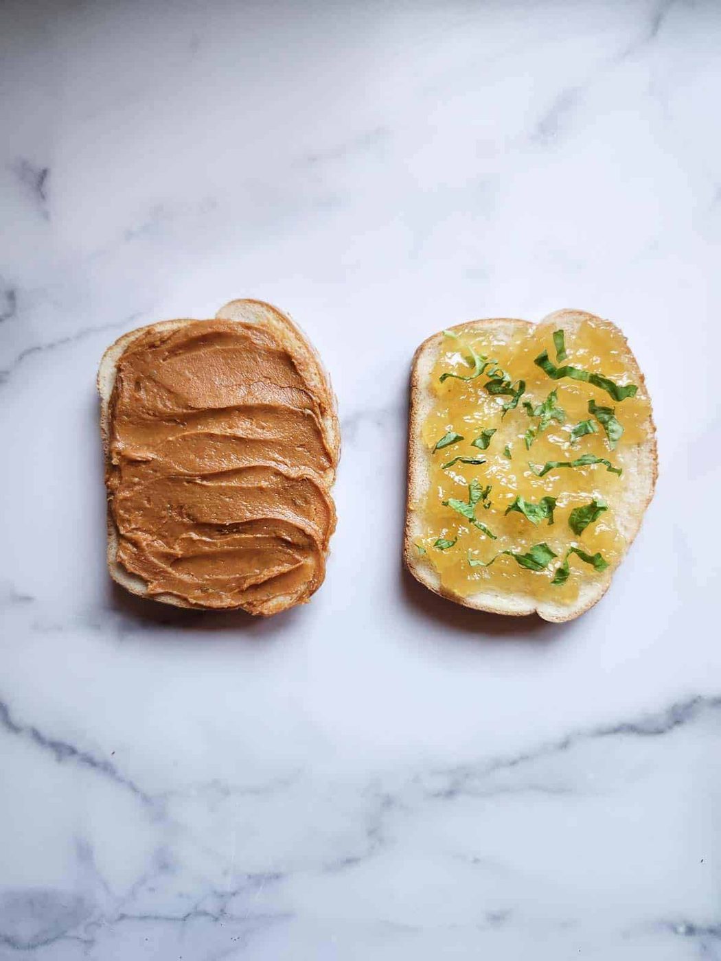 Two slices of bread with peanut butter and jam.