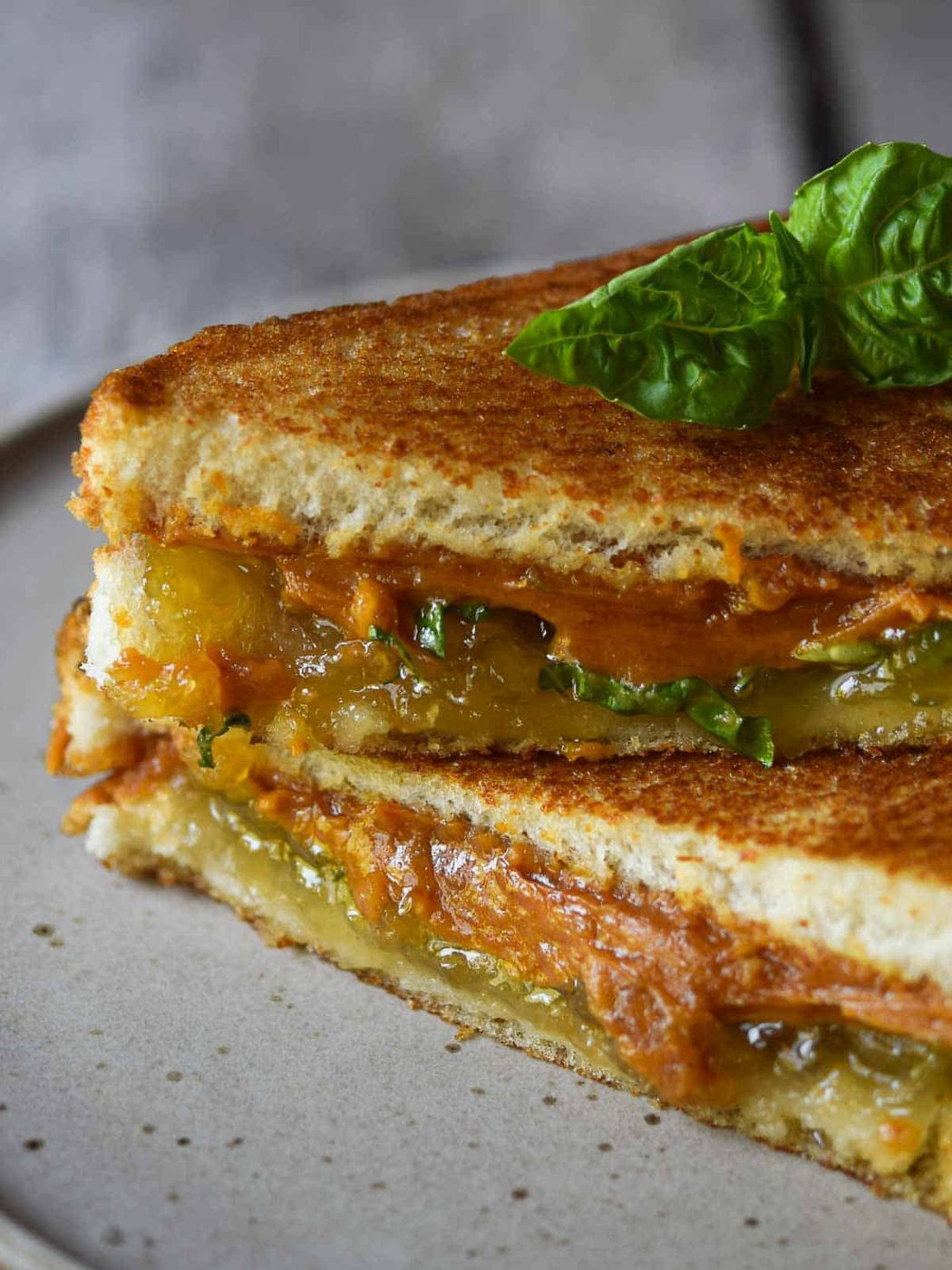 Thai peanut butter and jelly sandwich cut diagonally and stacked on a plate.