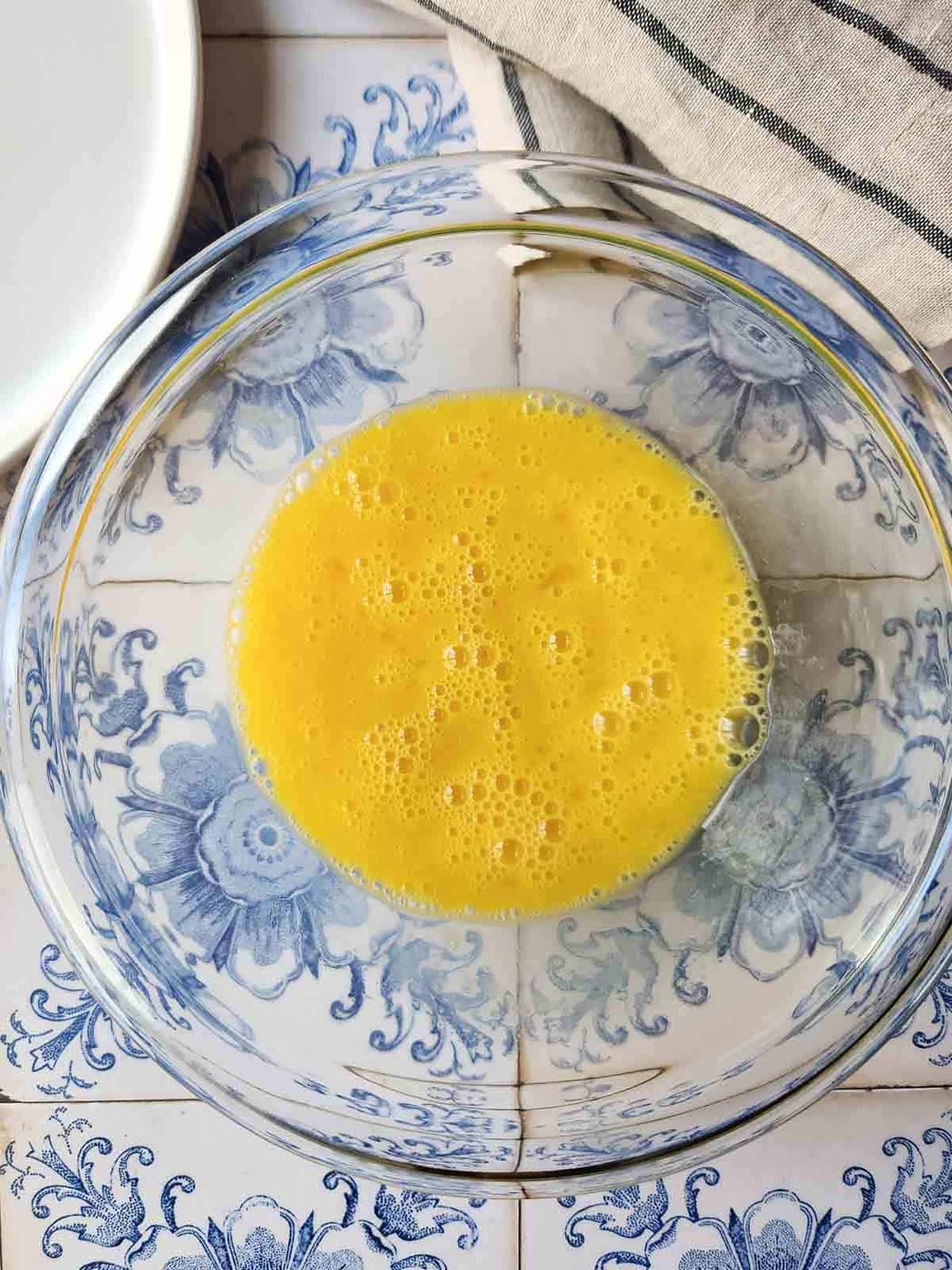 Whisked eggs in a clear bowl.