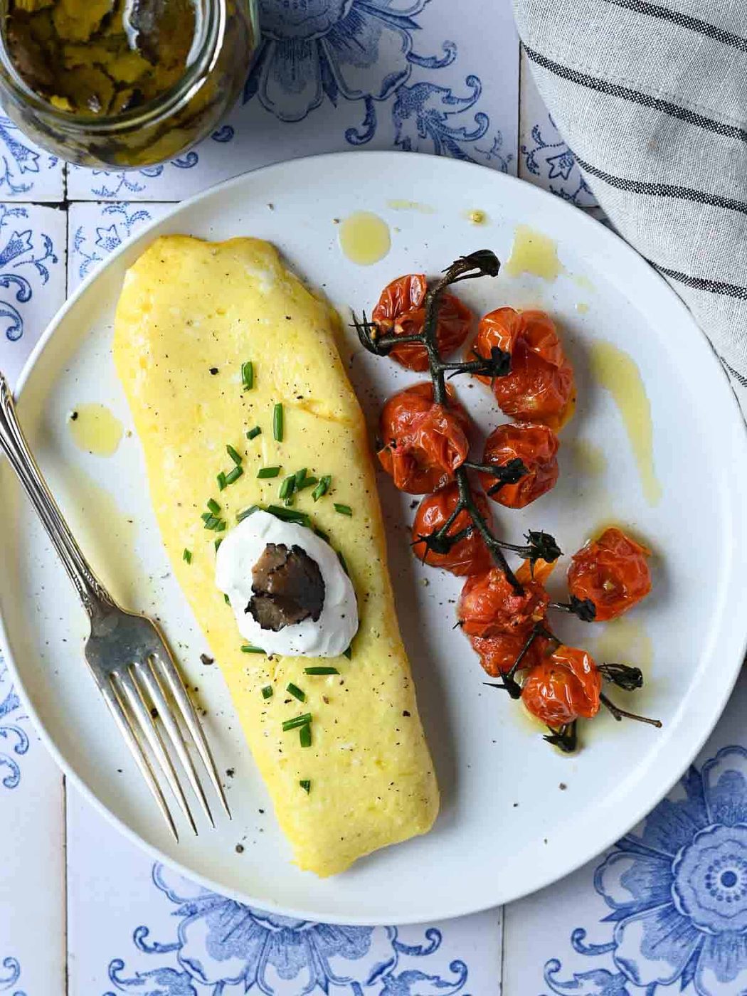 Overhead of a truffle omelet with tomatoes and creme fraiche.