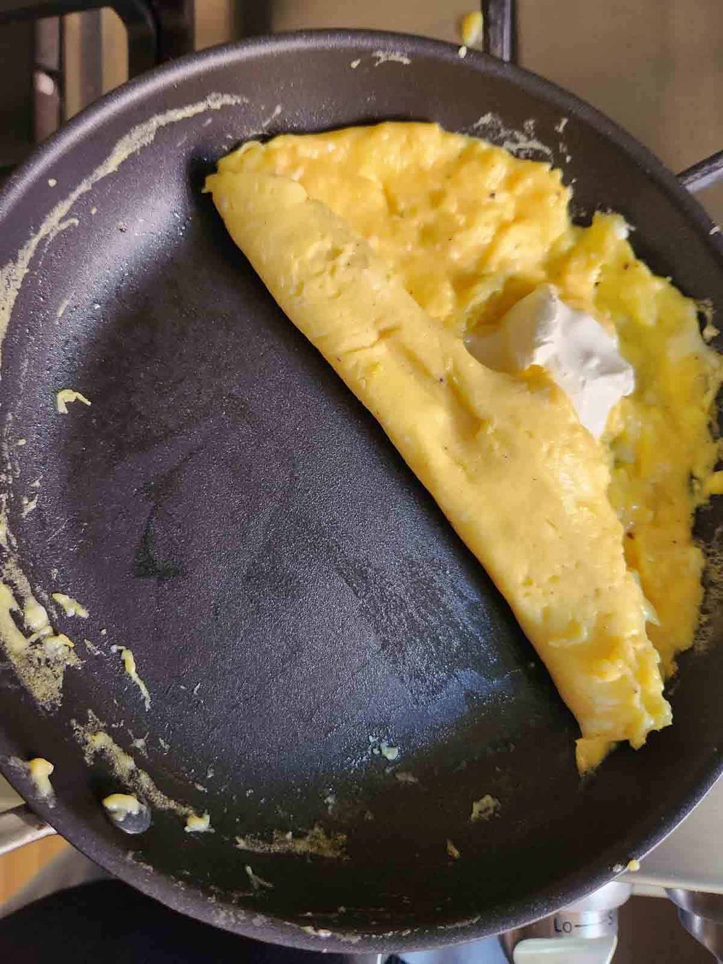 Technique showing the folding of a French omelet in a pan.