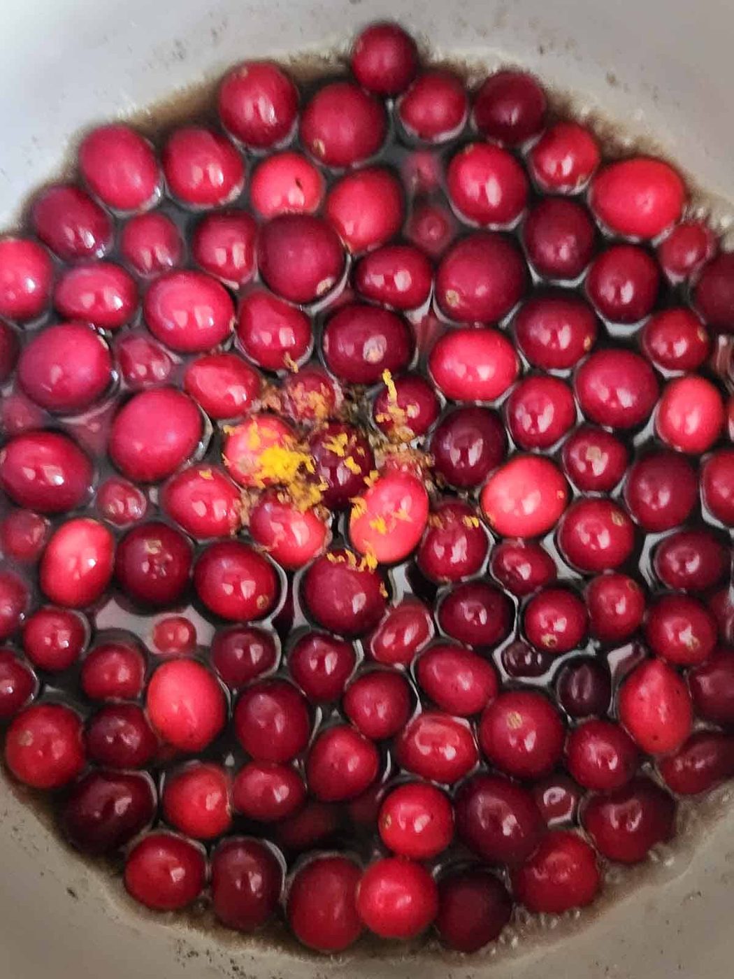 Cranberries, and syrup in a pot.