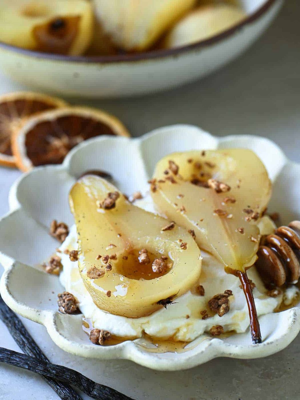 Poached pears in a flower plate with granola.