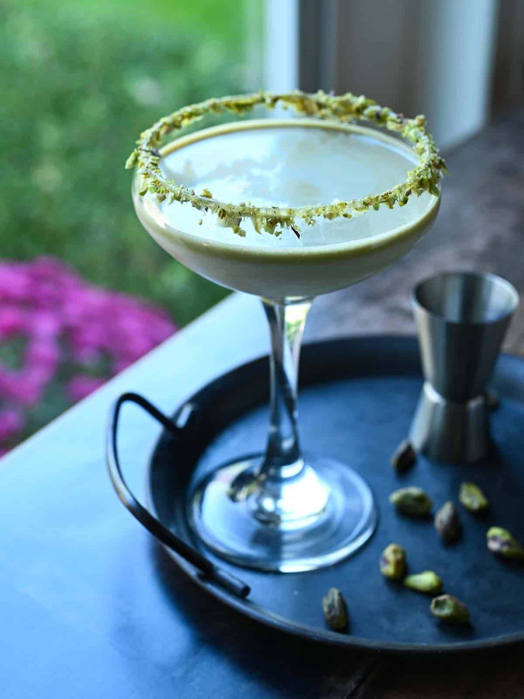 White chocolate pistachio martini backlight by a window.