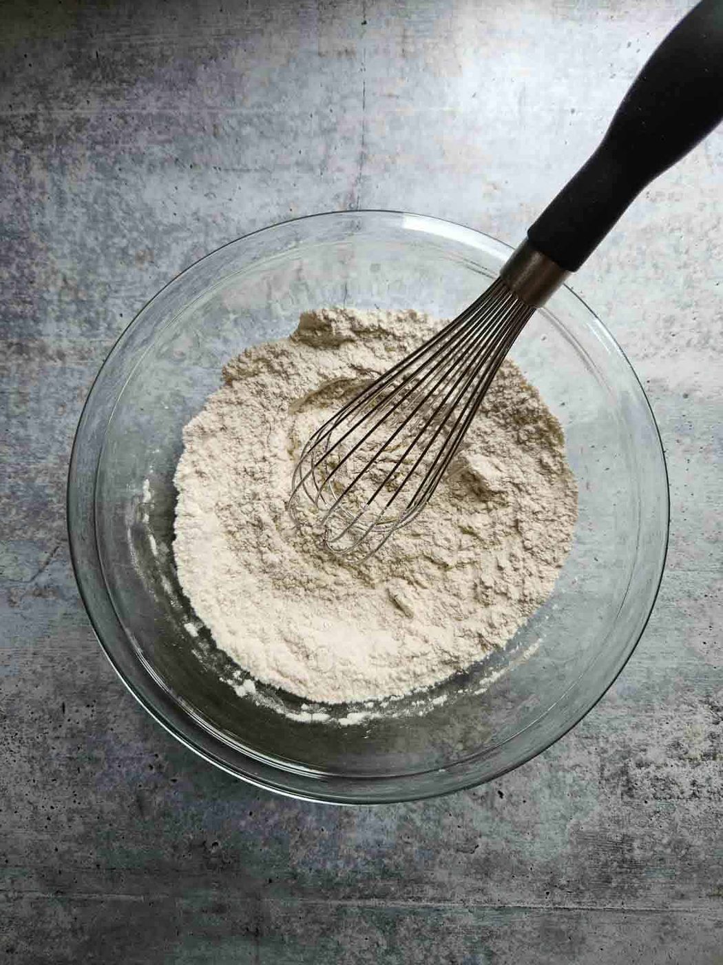 Dry ingredients for muffins in a clear bowl.