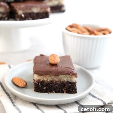 An Almond Joy Brownie on a white plate over a white and blue striped napkin.