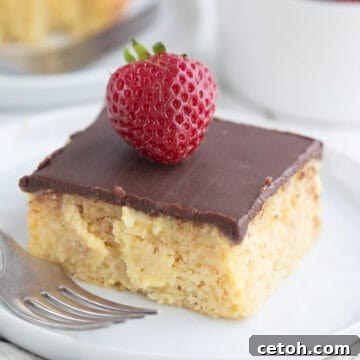 Close up shot of a slice of Keto Boston Cream Poke Cake on a white plate.