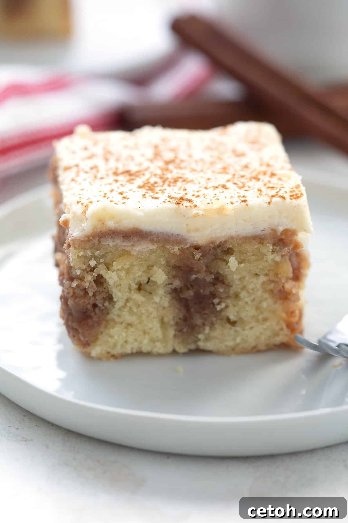 Close up shot of a slice of cinnamon roll poke cake.