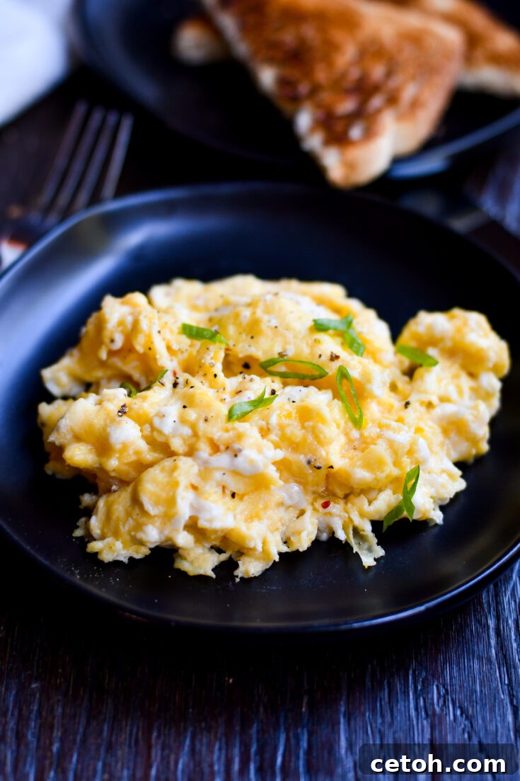 A close-up of Gordon Ramsay's creamy scrambled eggs on toast, garnished with fresh chives, ready to be enjoyed.