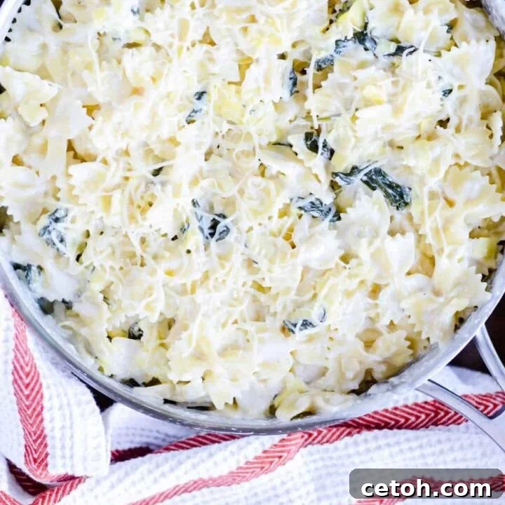 Creamy Spinach Artichoke Bowtie Pasta garnished with fresh parsley