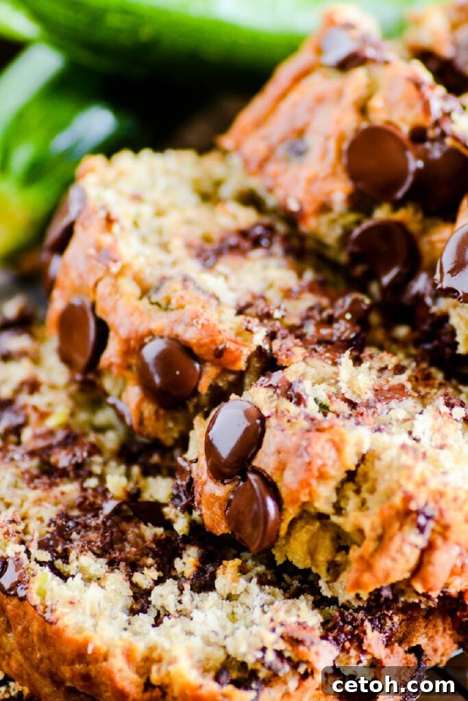 A delicious slice of chocolate chip zucchini banana bread on a white plate with a fork. Perfect for a healthy treat or a quick breakfast, loved by kids and adults.