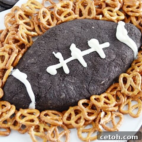 Touchdown Desserts: 15 Effortless Super Bowl Sweets 6 A delicious cookies and cream cheese ball shaped like a football, served with various dippers like pretzels, fruit, and graham crackers.
