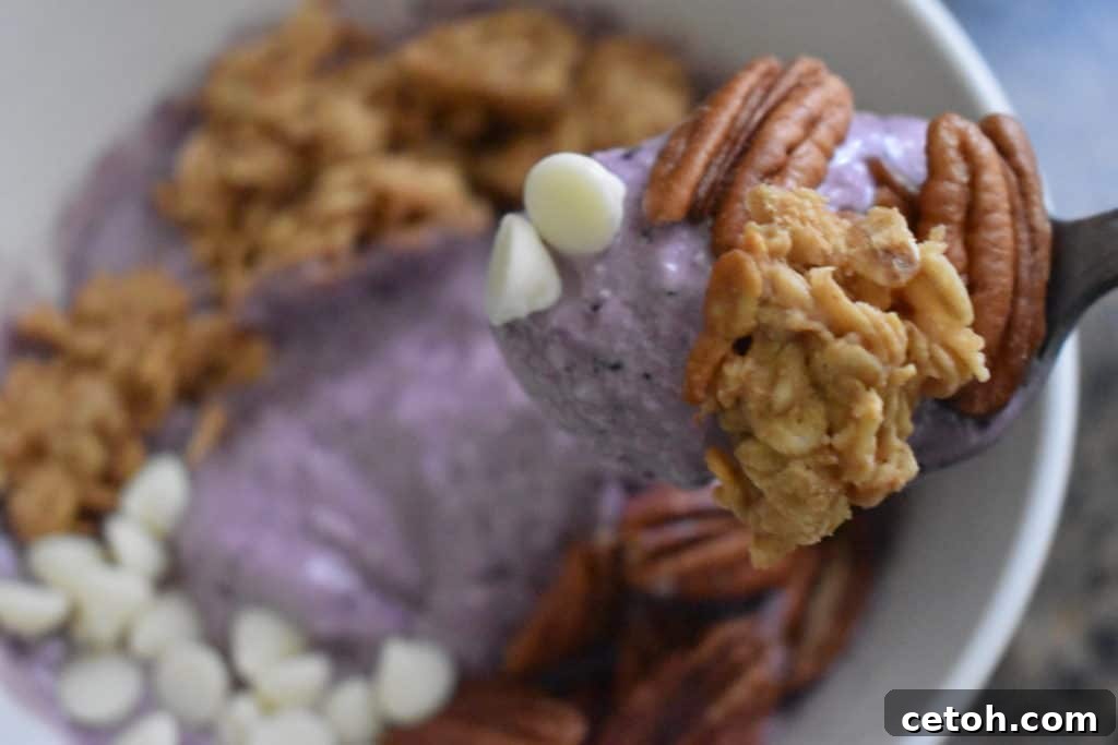 Healthy blueberry banana smoothie bowl recipe, garnished with fresh fruit and nuts.