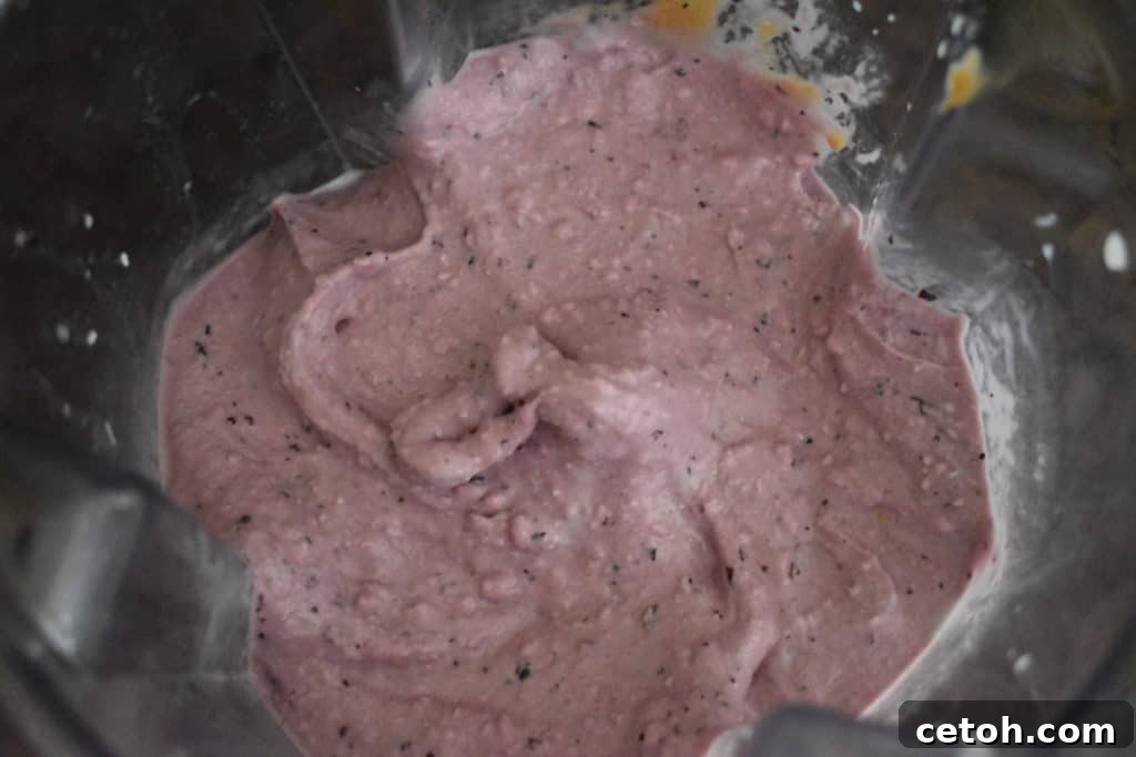 The creamy, perfectly blended base of a homemade fruit smoothie for a bowl.