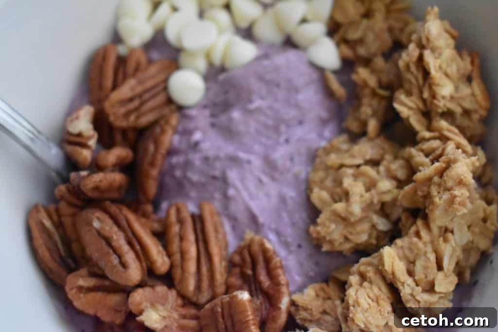 A vibrant healthy blueberry banana smoothie bowl generously adorned with delicious and nutritious toppings like granola, nuts, and fresh fruit.