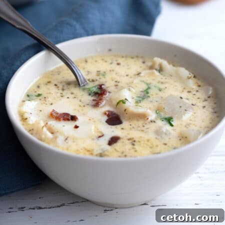 Keto Ocean Harvest Stew 2 Close up shot of a white bowl filled with keto seafood chowder, garnished with fresh dill and bacon.