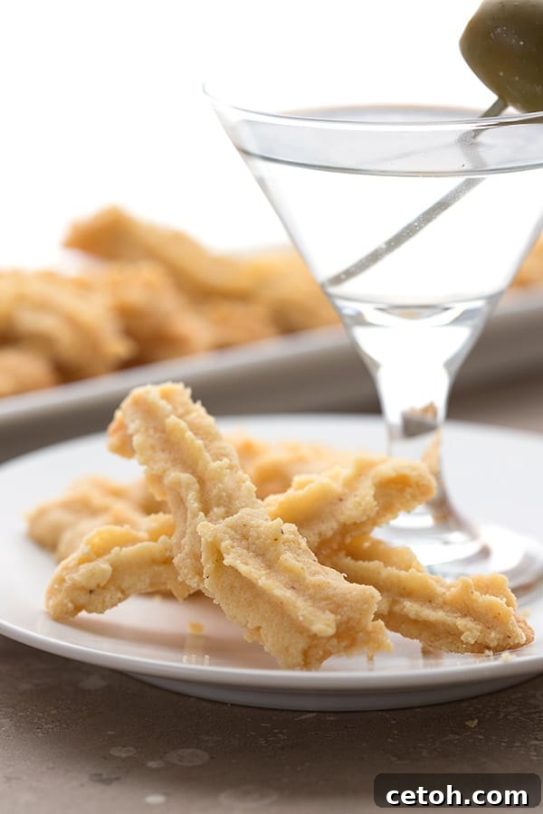 Keto cheese straws on a plate with a martini. 