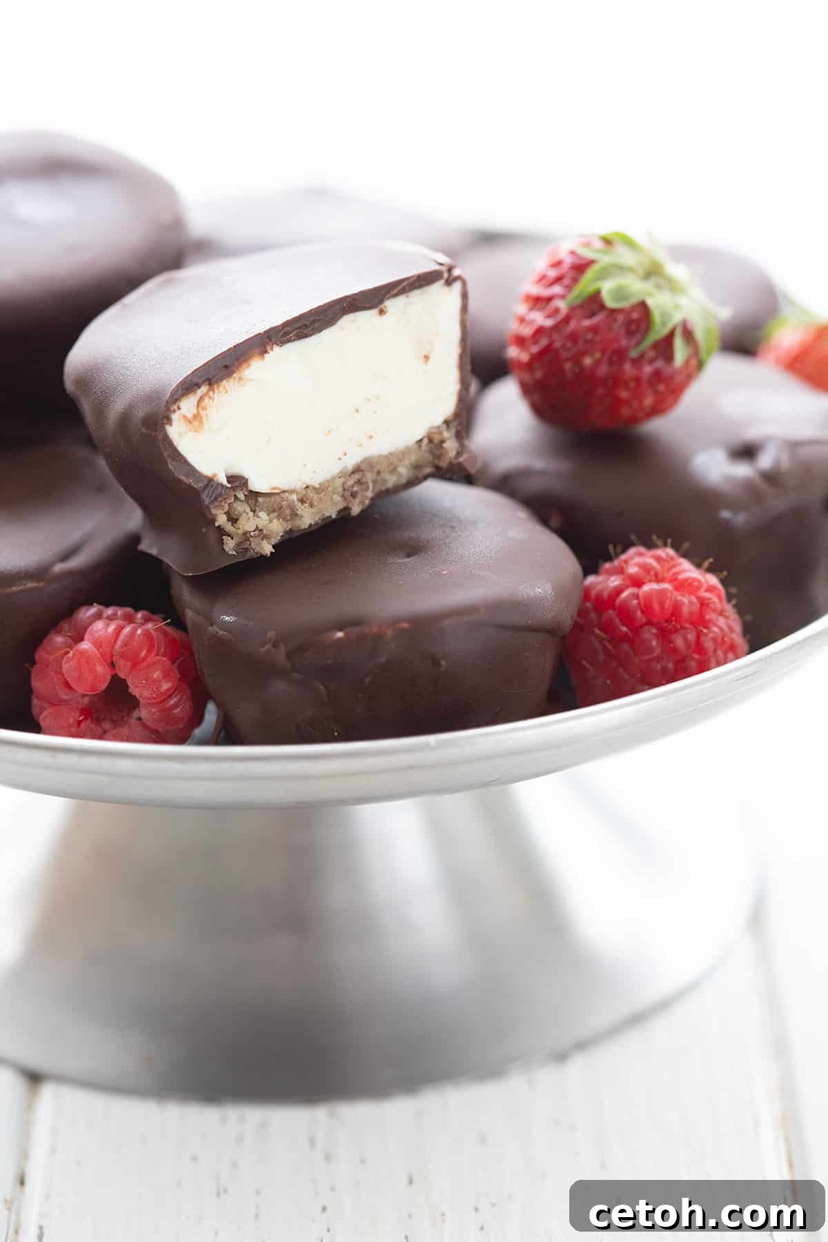 Keto Countdown Nibbles for New Year's Eve 22 Keto Cheesecake Bites in a metal cake stand with fresh berries.