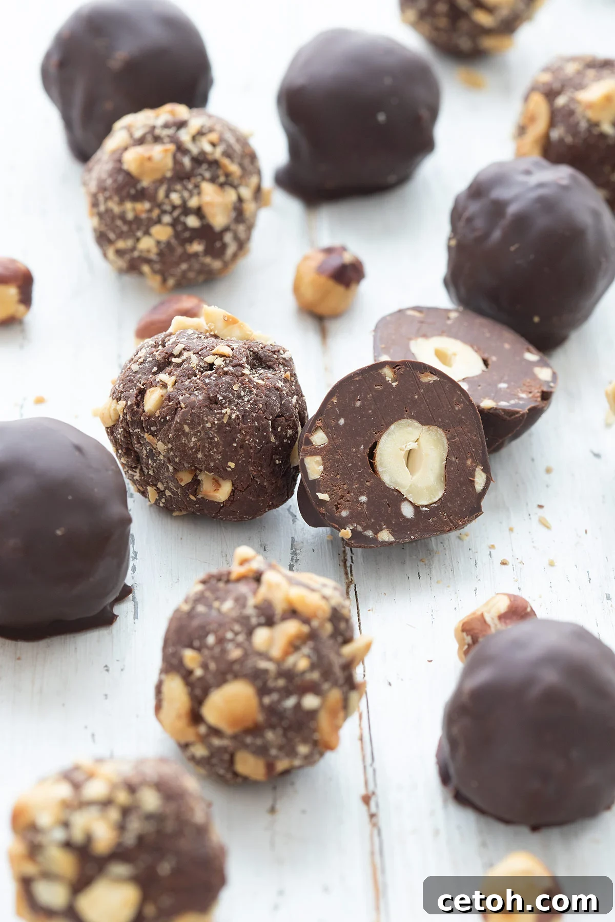 Keto Countdown Nibbles for New Year's Eve 25 Keto Chocolate Hazelnut Truffles on a white wooden table.