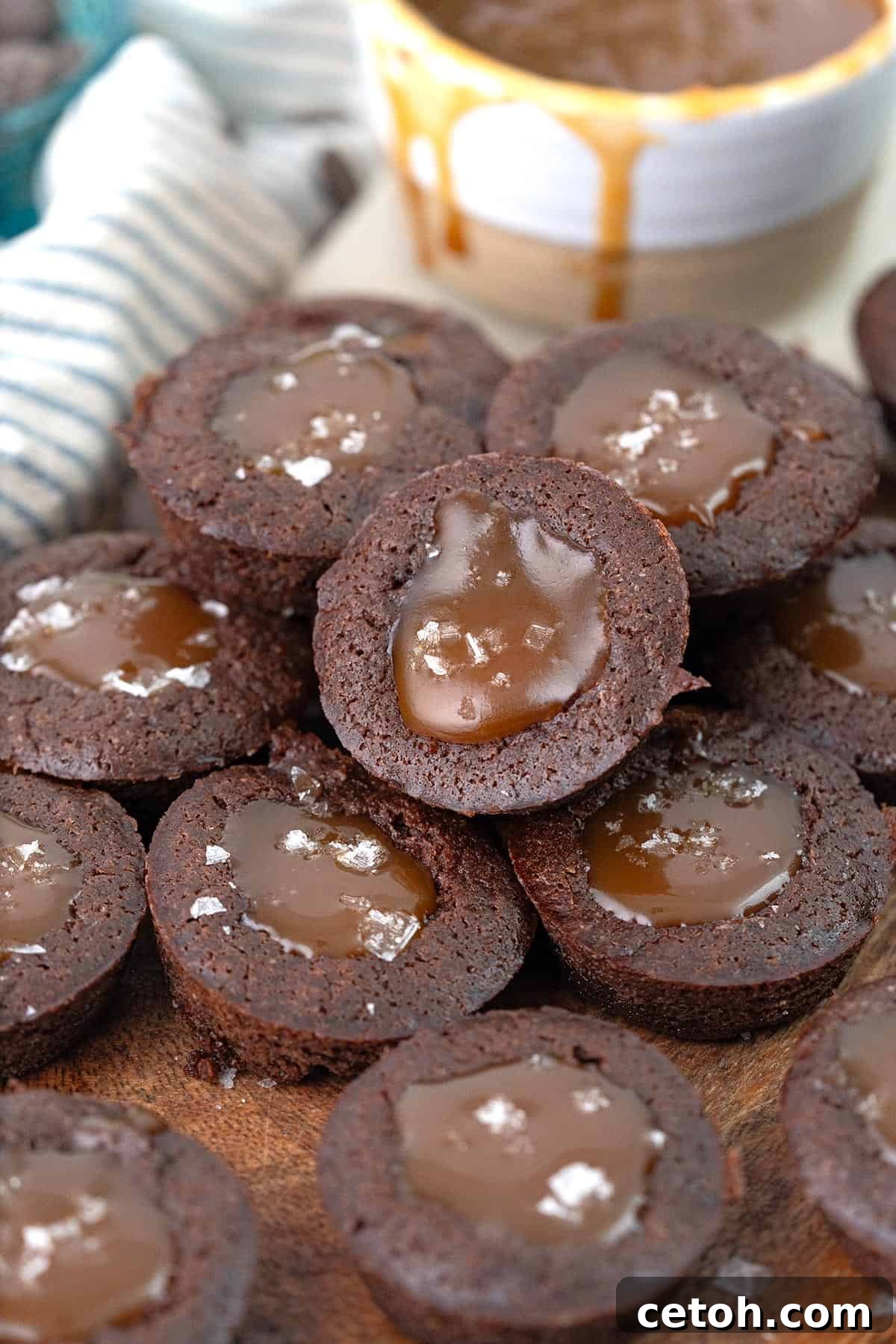 Keto Countdown Nibbles for New Year's Eve 26 A pile of keto brownie bites filled with caramel cause on a wooden cutting board.