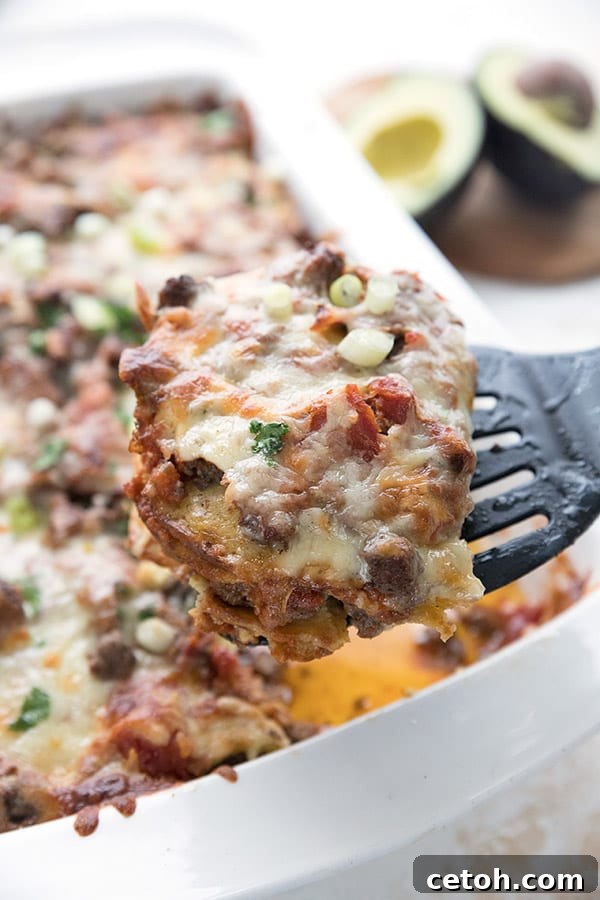 Close up of a slice of keto enchilada casserole being lifted out of the pan. 