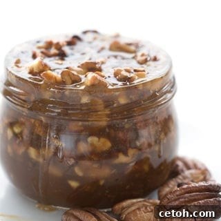 A delicious jar of homemade Keto Praline Pecan Sauce, ready to be enjoyed with various keto treats.