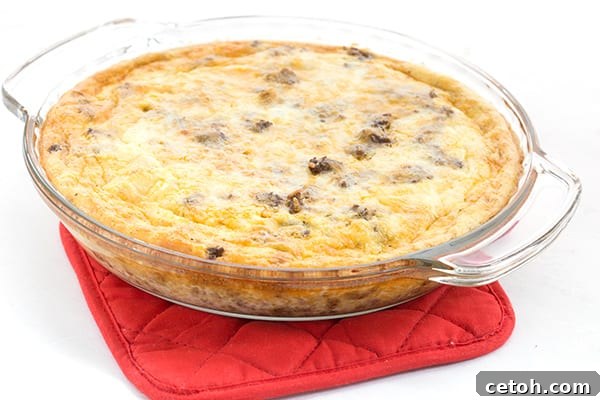 Easy taco pie in a pie plate on a red oven mitt, showcasing a delicious and simple keto casserole.