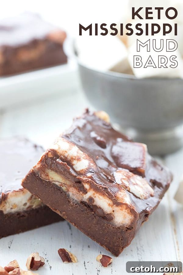 Close up shot of keto Mississippi Mud Bars with a bowl of marshmallows in the background, showcasing the rich layers.