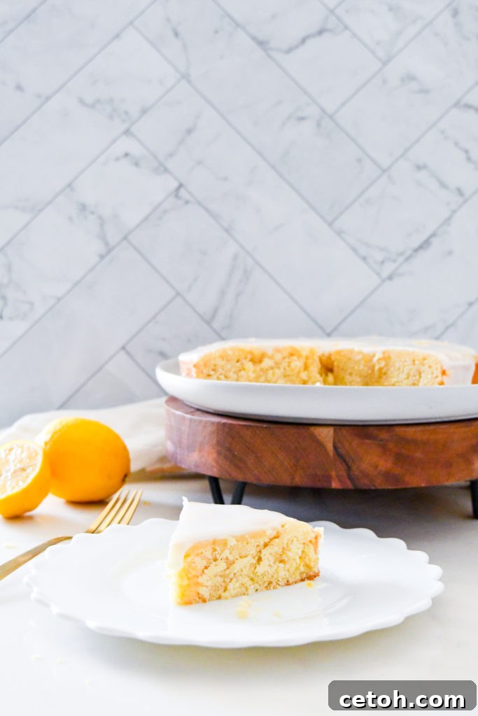 A beautifully presented lemon syrup cake, golden brown, sliced, and adorned with fresh lemon wedges, highlighting its dense, moist crumb and glistening lemon glaze, perfect for a spring gathering.