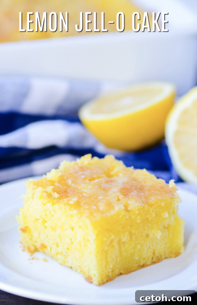 A generous slice of Simple Lemon Jell-O Cake, showcasing its light, airy texture and cheerful yellow color, often topped with a fluffy dollop of whipped cream for extra indulgence.